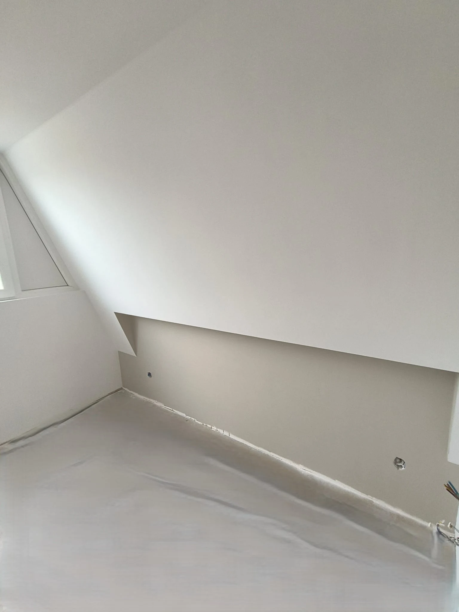 Strak afgewerkte schuine wand en plafond, met afgedekte vloer